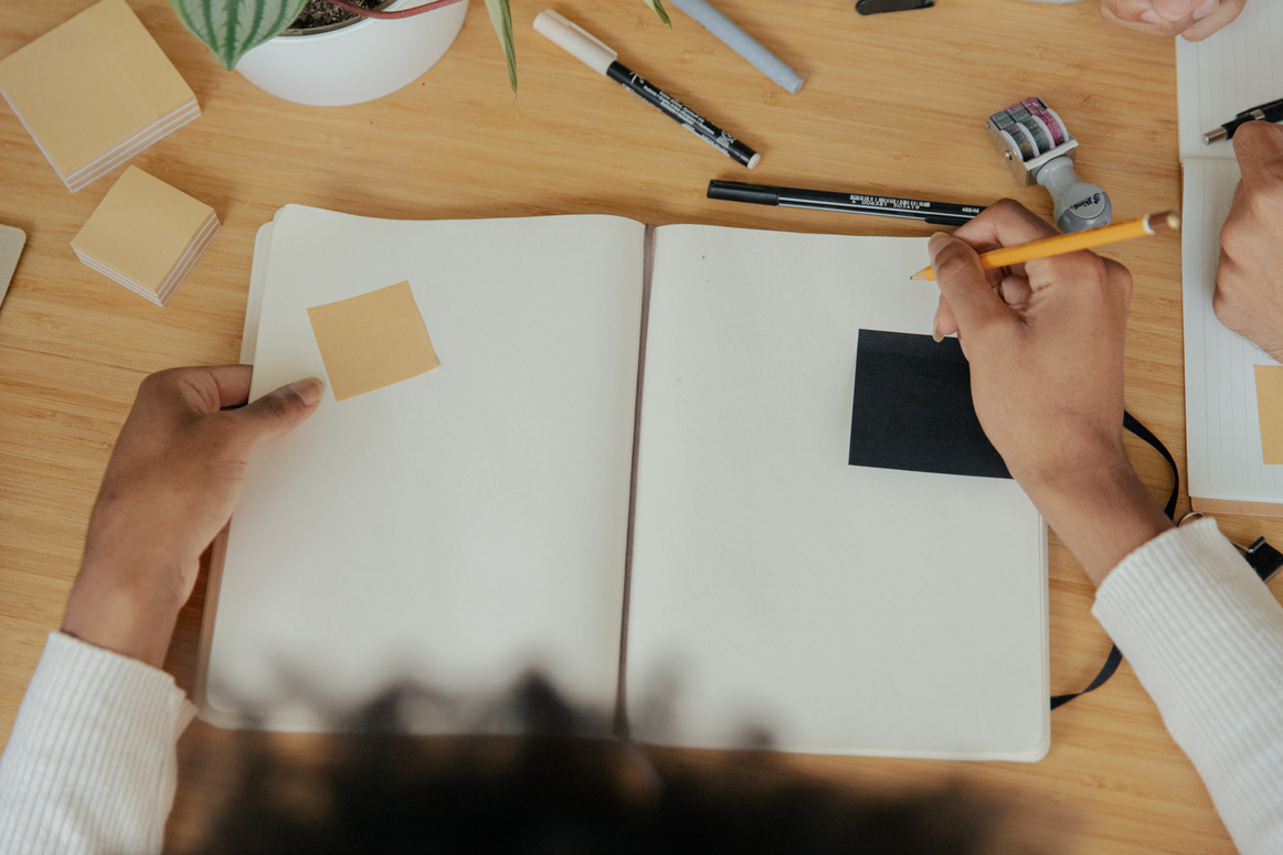 Top View of Businessperson Writing Ideas on a Notebook